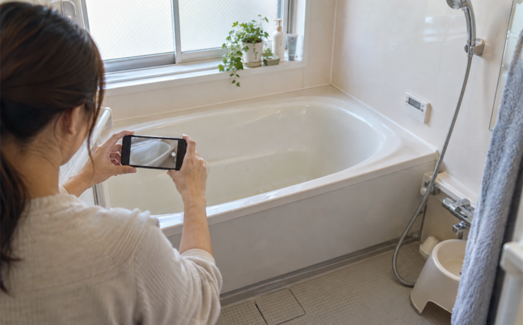 浴槽表面の異変をスマートフォンで記録する様子