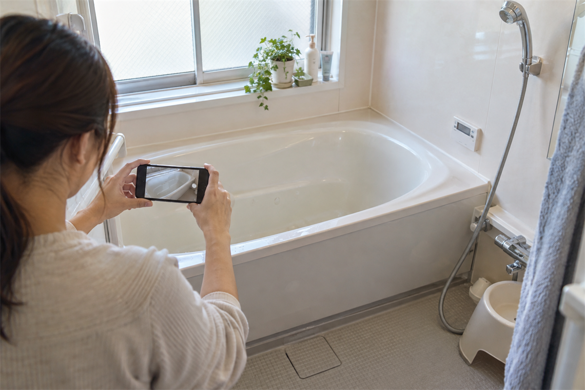 浴槽表面の異変をスマートフォンで記録する様子